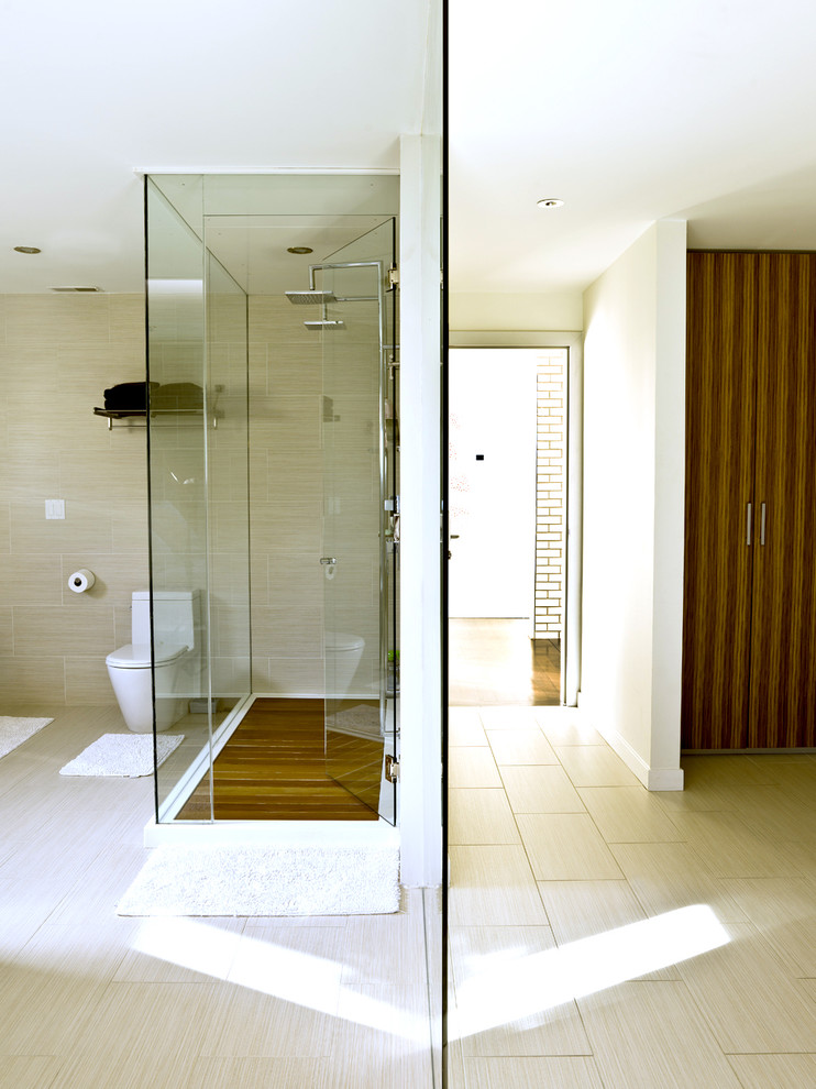 Réalisation d'une salle de bain design avec une douche double et un carrelage beige.