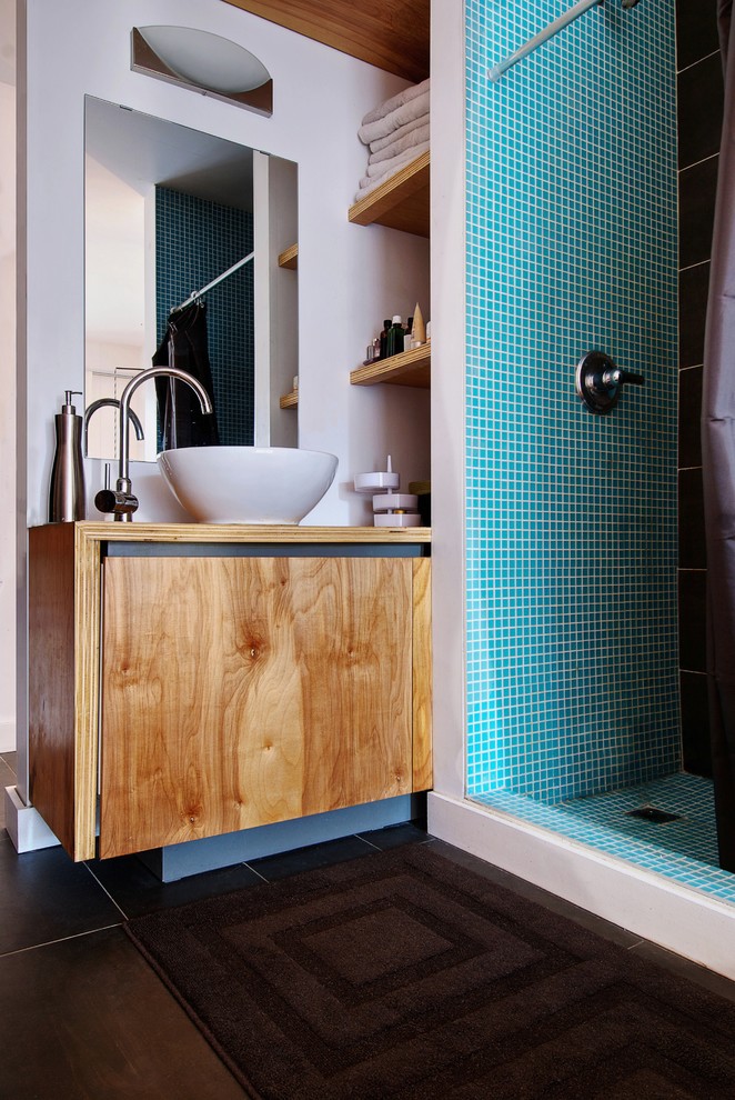 トロントにあるモダンスタイルのおしゃれな浴室 (ベッセル式洗面器、中間色木目調キャビネット、アルコーブ型シャワー、黒いタイル) の写真