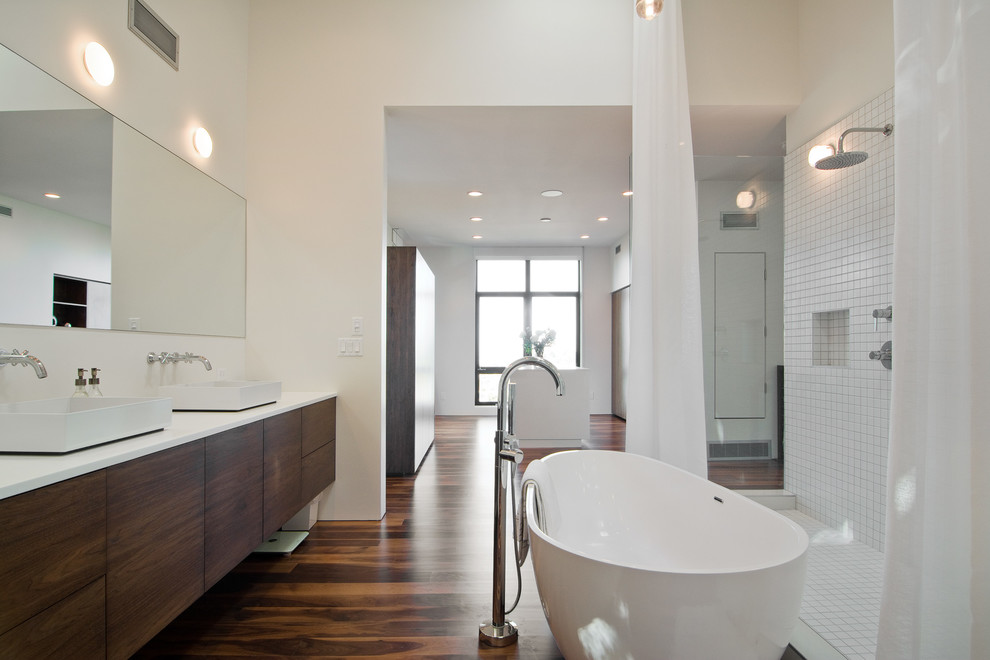 Cette image montre une salle de bain minimaliste avec une baignoire indépendante, une douche ouverte, une vasque et une cabine de douche avec un rideau.