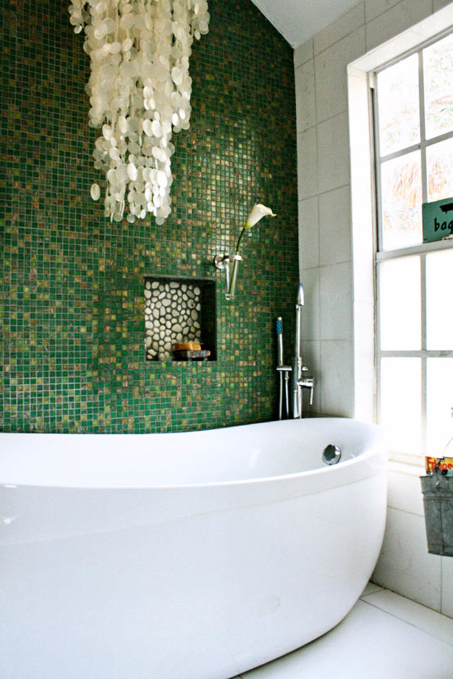 Idée de décoration pour une salle de bain bohème avec une baignoire indépendante et un mur vert.