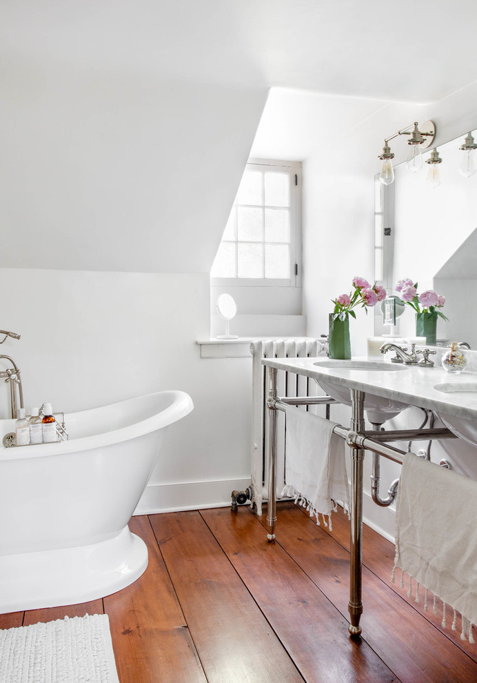 Пример оригинального дизайна: ванная комната в стиле кантри с отдельно стоящей ванной, белыми стенами, темным паркетным полом, врезной раковиной, коричневым полом и белой столешницей