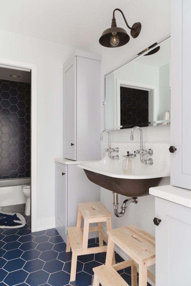 Ejemplo de cuarto de baño infantil y doble nórdico con baldosas y/o azulejos negros, paredes blancas, lavabo suspendido y suelo azul