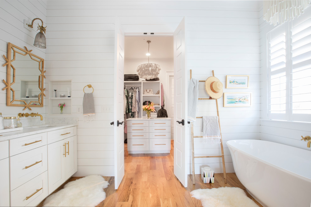 Inspiration för ett maritimt vit vitt en-suite badrum, med skåp i shakerstil, vita skåp, ett fristående badkar, vita väggar, mellanmörkt trägolv, ett undermonterad handfat och brunt golv