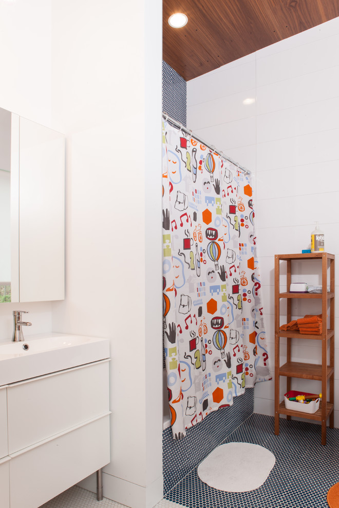 Modelo de cuarto de baño contemporáneo con armarios con paneles lisos, puertas de armario blancas, bañera empotrada, combinación de ducha y bañera, baldosas y/o azulejos blancos y paredes blancas