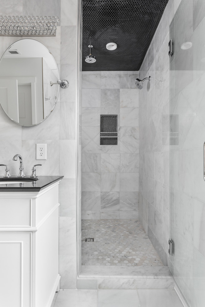 Idéer för ett stort klassiskt svart en-suite badrum, med luckor med profilerade fronter, vita skåp, ett hörnbadkar, en dusch/badkar-kombination, en toalettstol med hel cisternkåpa, grå kakel, marmorkakel, grå väggar, marmorgolv, ett undermonterad handfat, granitbänkskiva, grått golv och med dusch som är öppen