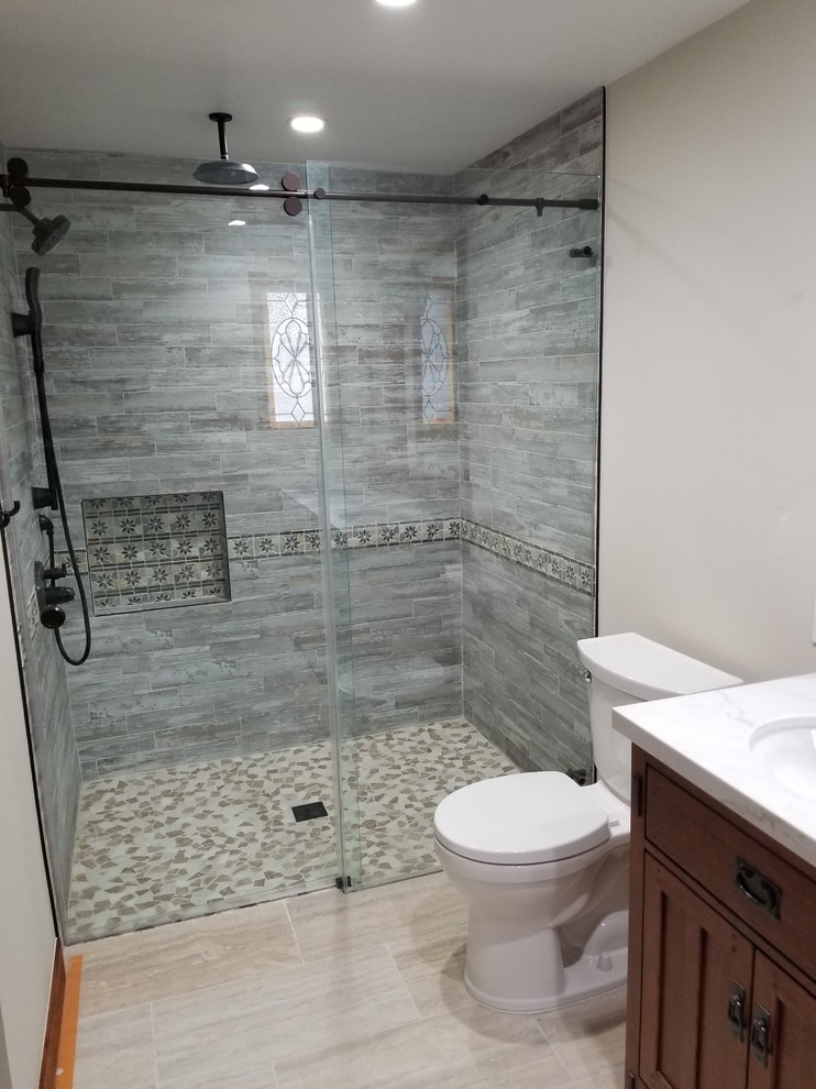Bild på ett mellanstort funkis badrum, med luckor med infälld panel, svarta skåp, en toalettstol med hel cisternkåpa, blå väggar, bambugolv, ett integrerad handfat och bänkskiva i akrylsten