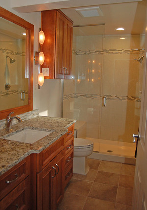 This is an example of a medium sized classic shower room bathroom in Seattle with recessed-panel cabinets, medium wood cabinets, an alcove shower, grey tiles, ceramic tiles, white walls, cement flooring, a submerged sink, granite worktops, beige floors, a hinged door, a built-in bath and a one-piece toilet.