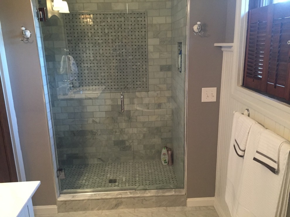 Cette image montre une grande salle de bain principale design avec des portes de placard blanches, une douche d'angle, un carrelage gris, un carrelage de pierre, un mur gris et un sol en carrelage de céramique.