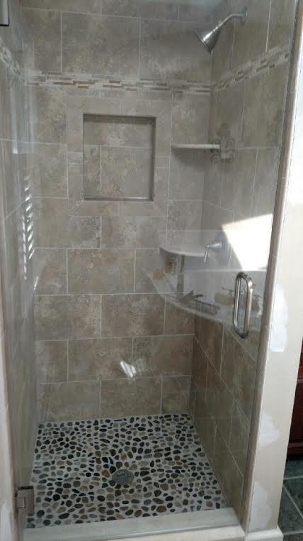 Bild på ett funkis badrum, med en dusch i en alkov och kakel i småsten