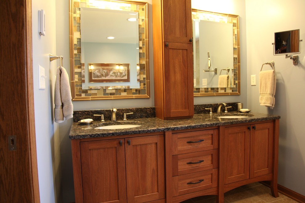 Photo of a medium sized classic bathroom in Milwaukee with a submerged sink, flat-panel cabinets, light wood cabinets, granite worktops, beige tiles, mosaic tiles, blue walls and porcelain flooring.