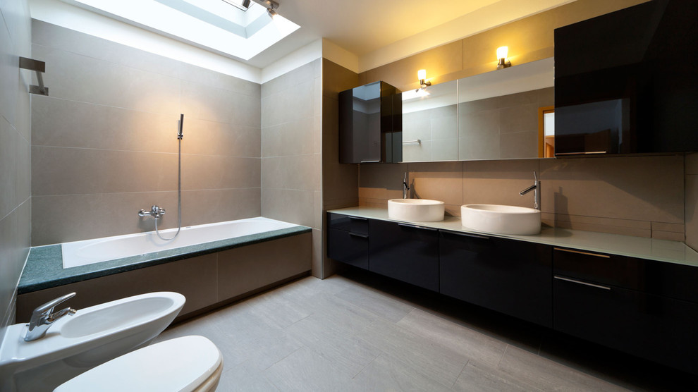 Immagine di una grande stanza da bagno padronale contemporanea con lavabo a bacinella, ante lisce, ante in legno bruno, vasca ad alcova, bidè e pareti beige