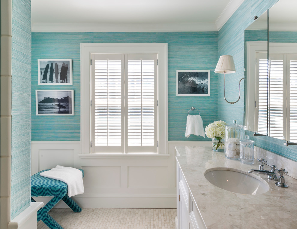Cette photo montre une salle de bain bord de mer avec un lavabo encastré, un placard avec porte à panneau encastré, des portes de placard blanches, un mur bleu et un sol en carrelage de terre cuite.