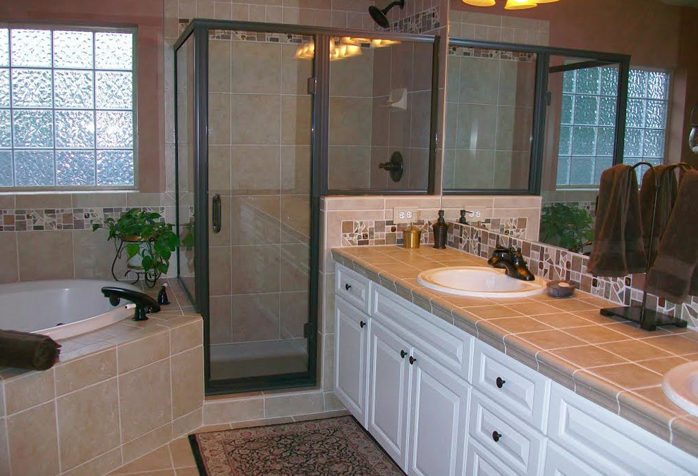 Inspiration for a large traditional ensuite bathroom in Denver with a built-in sink, raised-panel cabinets, white cabinets, a hot tub, a corner shower, beige tiles, ceramic tiles, beige walls and ceramic flooring.