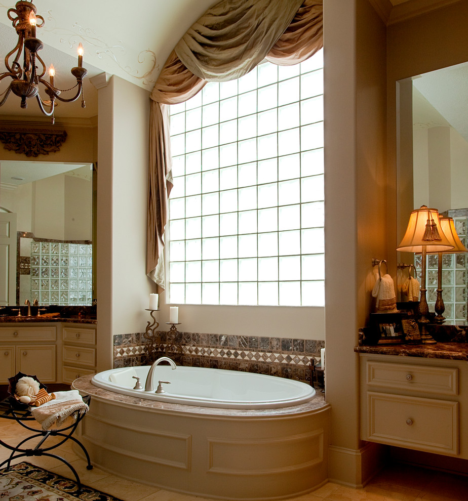 Huge elegant master beige tile and gray tile drop-in bathtub photo in Houston