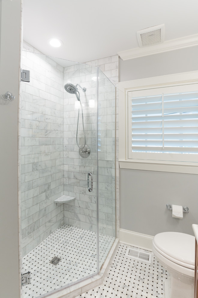 Inredning av ett klassiskt litet badrum med dusch, med luckor med upphöjd panel, skåp i mellenmörkt trä, en hörndusch, en toalettstol med hel cisternkåpa, grå kakel, marmorkakel, grå väggar, marmorgolv, ett integrerad handfat, bänkskiva i kvartsit, vitt golv och dusch med gångjärnsdörr