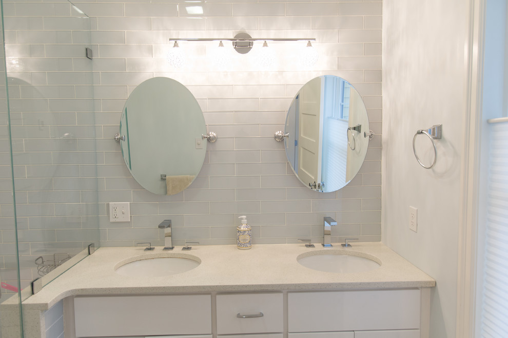 Corner shower - mid-sized transitional master blue tile and subway tile corner shower idea in Boston with flat-panel cabinets, white cabinets, blue walls, an undermount sink, quartz countertops and a hinged shower door