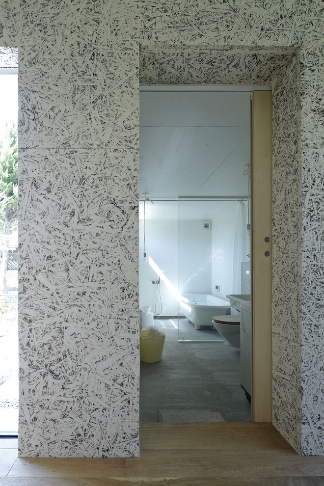 Foto di una stanza da bagno minimalista con vasca freestanding e piastrelle grigie