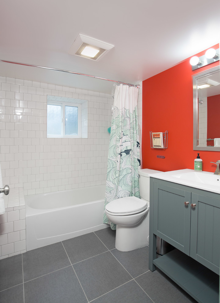 Ispirazione per una stanza da bagno classica di medie dimensioni con ante verdi, vasca ad alcova, vasca/doccia, WC a due pezzi, pareti arancioni, lavabo integrato e doccia con tenda