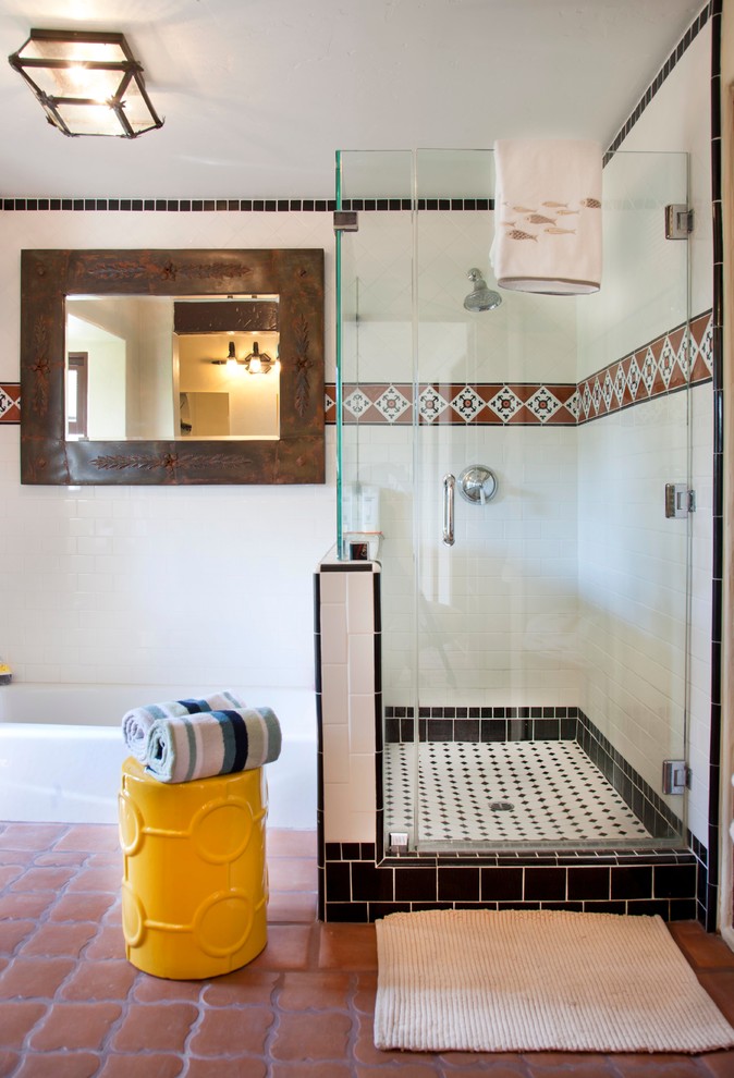 Cette image montre une salle de bain principale méditerranéenne de taille moyenne avec une douche d'angle, un mur blanc, tomettes au sol et un carrelage blanc.