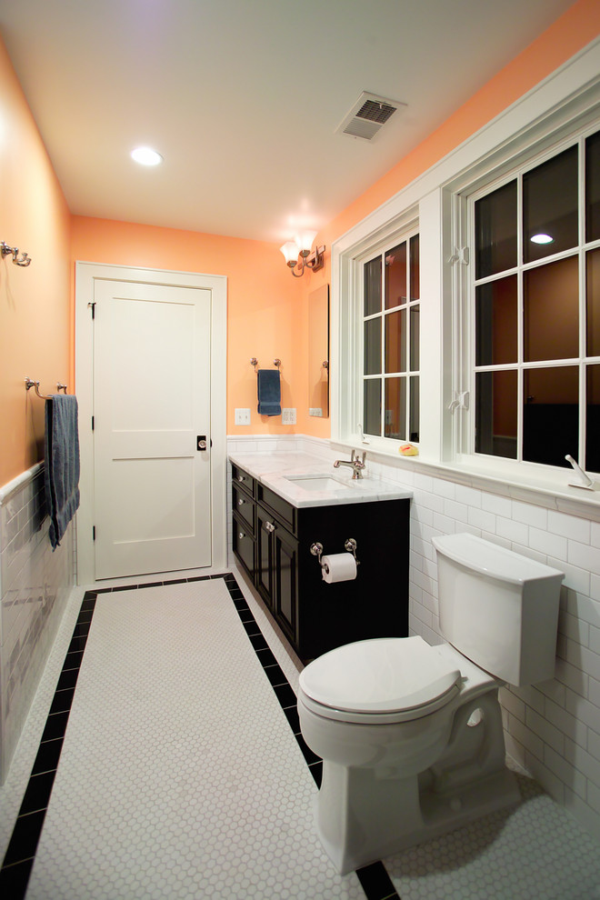 Стильный дизайн: узкая и длинная ванная комната в классическом стиле с врезной раковиной, фасадами с выступающей филенкой, черными фасадами, раздельным унитазом, белой плиткой, плиткой кабанчик и белым полом - последний тренд