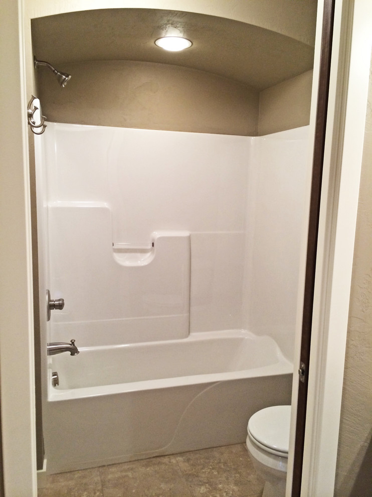 Cette image montre une salle de bain craftsman de taille moyenne pour enfant avec un lavabo posé, une baignoire indépendante, un combiné douche/baignoire et un mur beige.