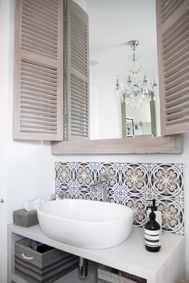 Immagine di una stanza da bagno mediterranea con pareti bianche e lavabo a bacinella