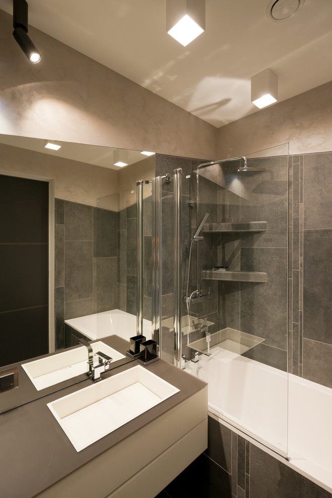 Modelo de cuarto de baño actual con combinación de ducha y bañera, paredes marrones y lavabo bajoencimera
