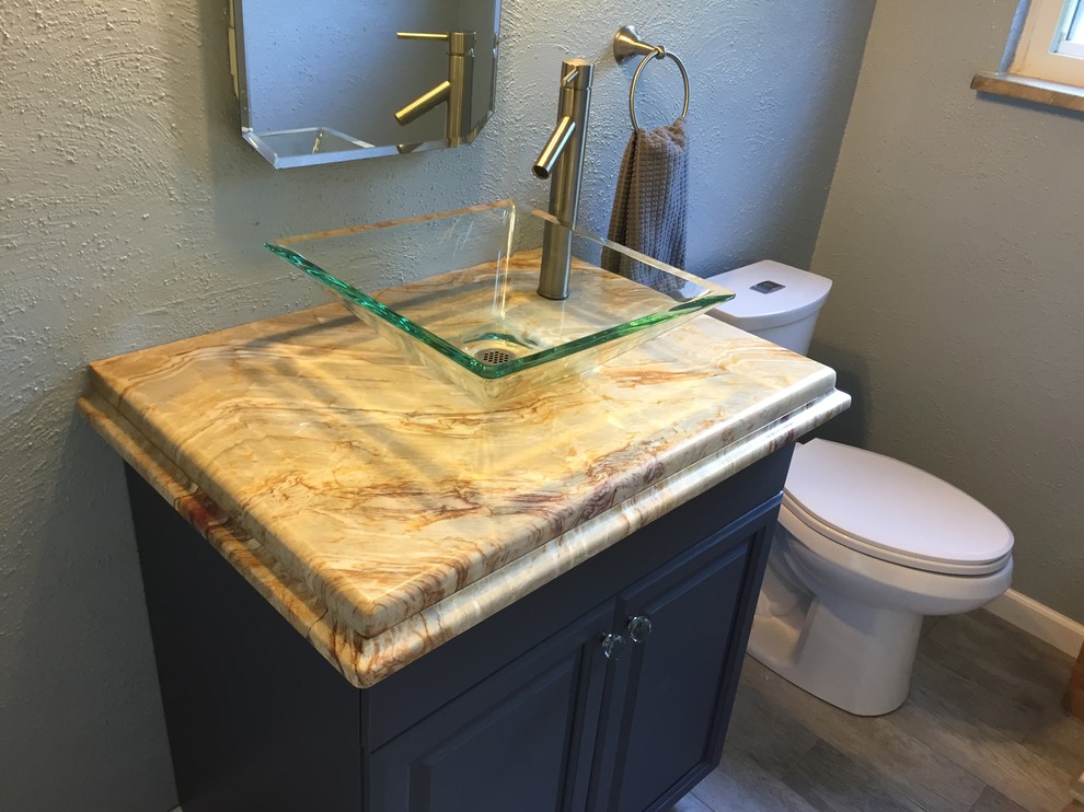 Exemple d'une petite salle de bain tendance en bois foncé avec une vasque, un placard avec porte à panneau encastré, un plan de toilette en quartz et un mur gris.
