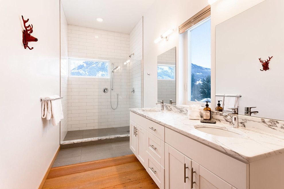Inspiration for a rustic 3/4 white tile and subway tile medium tone wood floor bathroom remodel in Seattle with shaker cabinets, white cabinets, white walls, an undermount sink and multicolored countertops