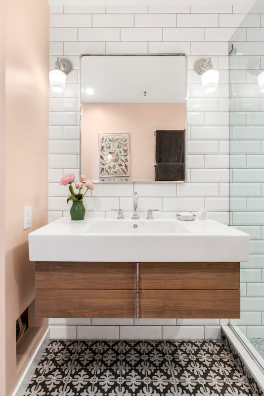 Mittelgroßes Klassisches Duschbad mit flächenbündigen Schrankfronten, hellbraunen Holzschränken, Eckdusche, Toilette mit Aufsatzspülkasten, weißen Fliesen, Metrofliesen, rosa Wandfarbe, integriertem Waschbecken, buntem Boden und Falttür-Duschabtrennung in New York