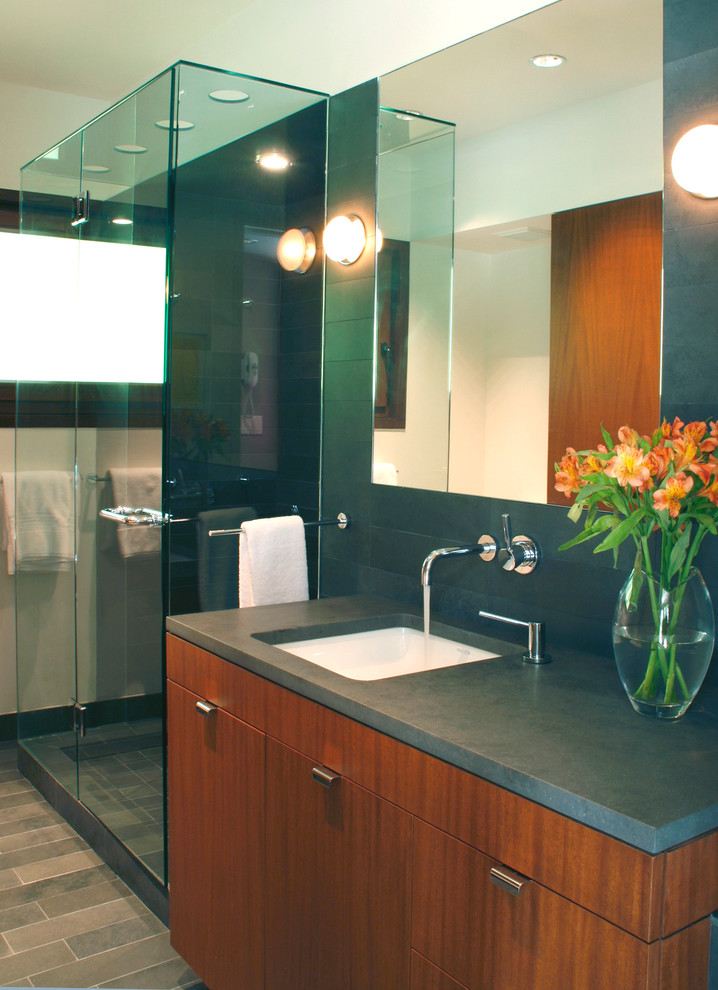 На фото: главная ванная комната среднего размера в стиле модернизм с плоскими фасадами, фасадами цвета дерева среднего тона, раздельным унитазом, серой плиткой, каменной плиткой, серыми стенами и серым полом