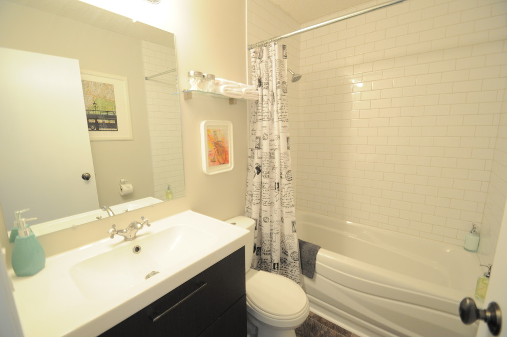 Mittelgroßes Shabby-Style Badezimmer mit dunklen Holzschränken, Badewanne in Nische, Wandtoilette mit Spülkasten, weißen Fliesen, Keramikfliesen, grauer Wandfarbe, Linoleum, integriertem Waschbecken und Mineralwerkstoff-Waschtisch in Calgary