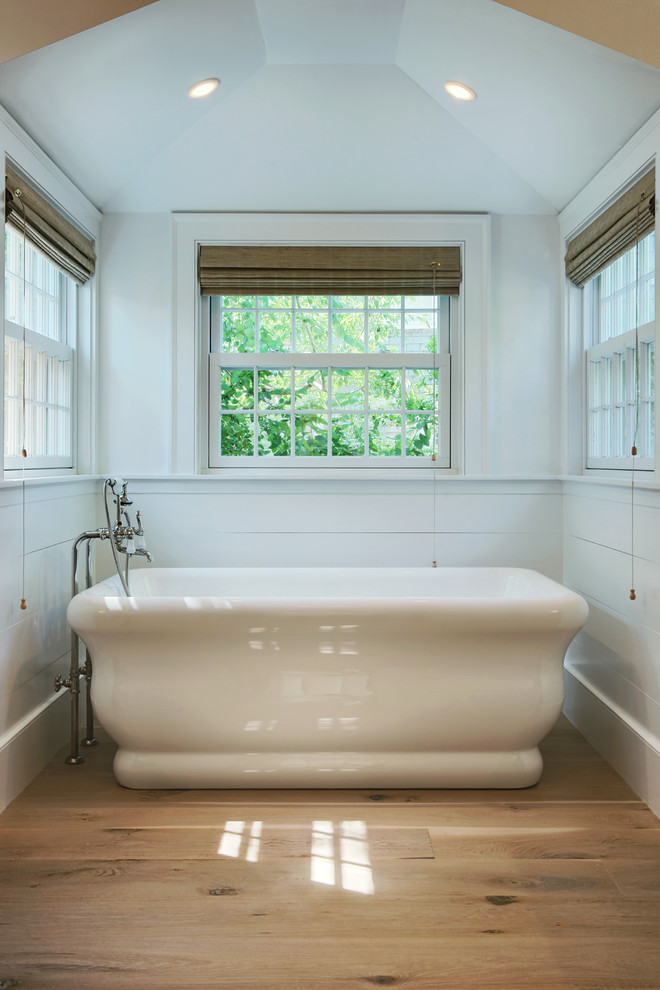 Inspiration for a small transitional master light wood floor freestanding bathtub remodel in Los Angeles with red walls