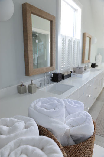 Idéer för att renovera ett stort maritimt en-suite badrum, med ett undermonterad handfat, släta luckor, vita skåp, bänkskiva i akrylsten, ett undermonterat badkar, grå kakel, stenkakel, grå väggar och kalkstensgolv