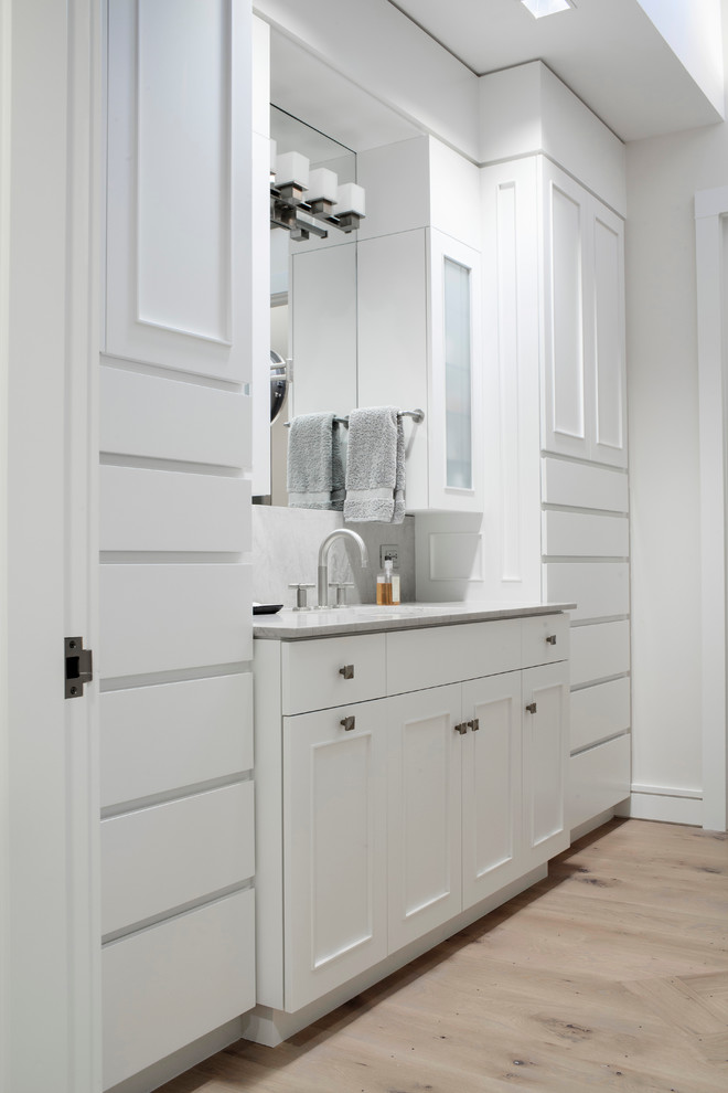 Photo of a medium sized rural ensuite bathroom in Boston with beaded cabinets, light wood cabinets, white tiles, stone slabs, white walls, light hardwood flooring and a built-in sink.