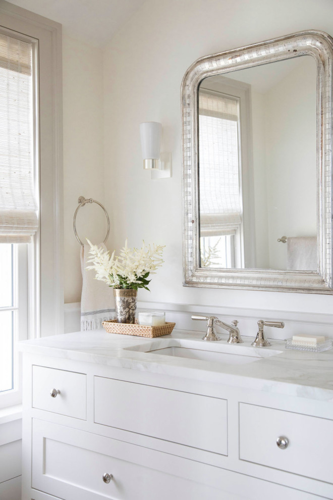 Immagine di una stanza da bagno costiera con ante in stile shaker, ante bianche, pareti bianche, lavabo sottopiano e top bianco