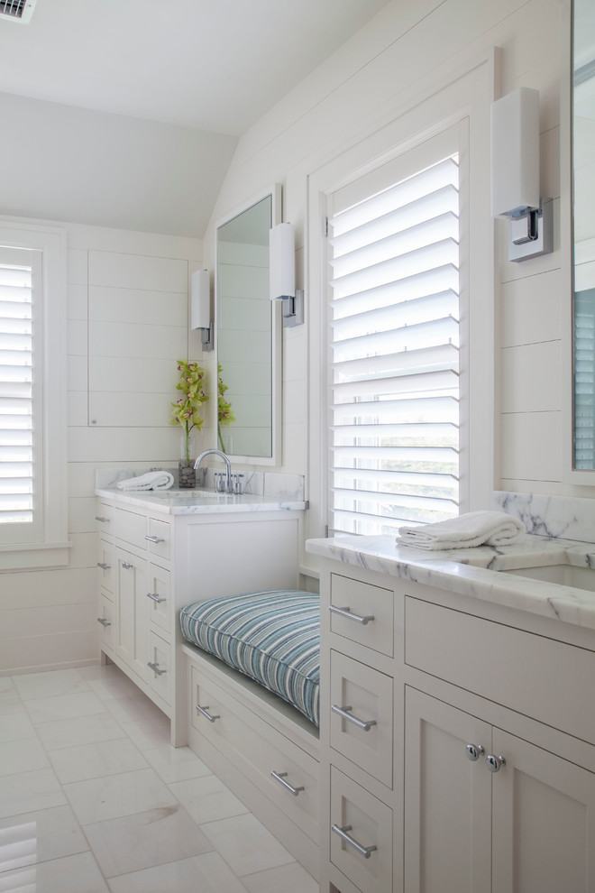 Foto de cuarto de baño principal costero con lavabo bajoencimera, armarios estilo shaker, puertas de armario beige y paredes blancas