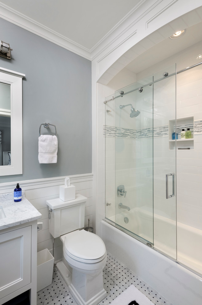 Foto på ett stort vintage badrum med dusch, med luckor med infälld panel, vita skåp, ett undermonterad handfat, marmorbänkskiva, ett badkar i en alkov, en dusch/badkar-kombination, mosaik, grå väggar, marmorgolv och en toalettstol med separat cisternkåpa