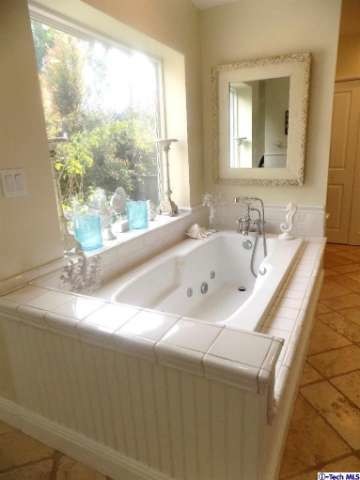 Immagine di una grande stanza da bagno padronale country con ante lisce, ante bianche, vasca da incasso e piastrelle bianche