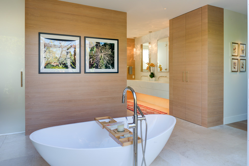 Ejemplo de cuarto de baño principal actual grande con bañera exenta, suelo de piedra caliza, encimera de piedra caliza, suelo beige y encimeras blancas