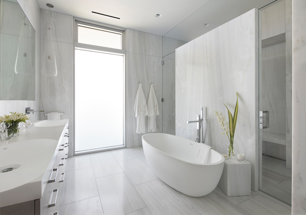 Example of a huge trendy master white tile and stone slab marble floor and white floor bathroom design in San Francisco with flat-panel cabinets, medium tone wood cabinets, a one-piece toilet, white walls, an integrated sink, solid surface countertops, a hinged shower door and white countertops