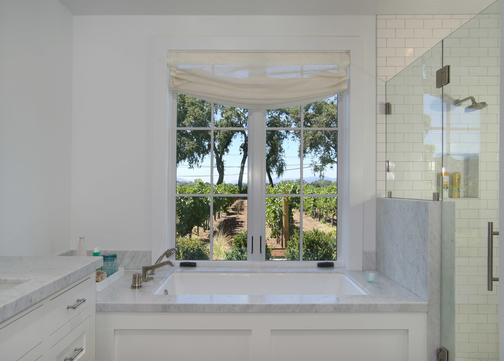 Ejemplo de cuarto de baño clásico renovado con bañera encastrada, baldosas y/o azulejos blancos, baldosas y/o azulejos de porcelana y encimera de mármol