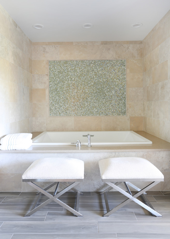 Aménagement d'une grande salle de bain principale montagne avec une baignoire posée, un carrelage beige, des carreaux de porcelaine, un sol en carrelage de porcelaine et un sol marron.