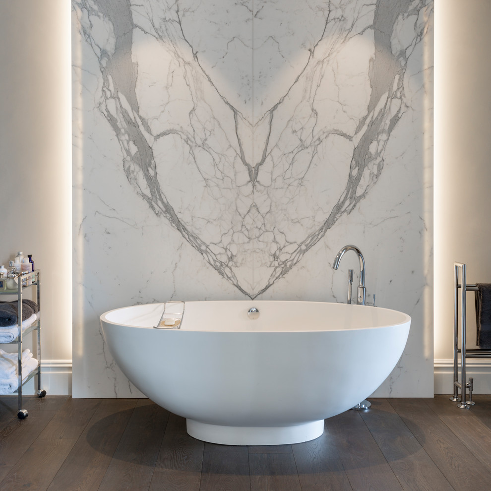 Modernes Badezimmer mit freistehender Badewanne, grauer Wandfarbe, dunklem Holzboden und braunem Boden in London