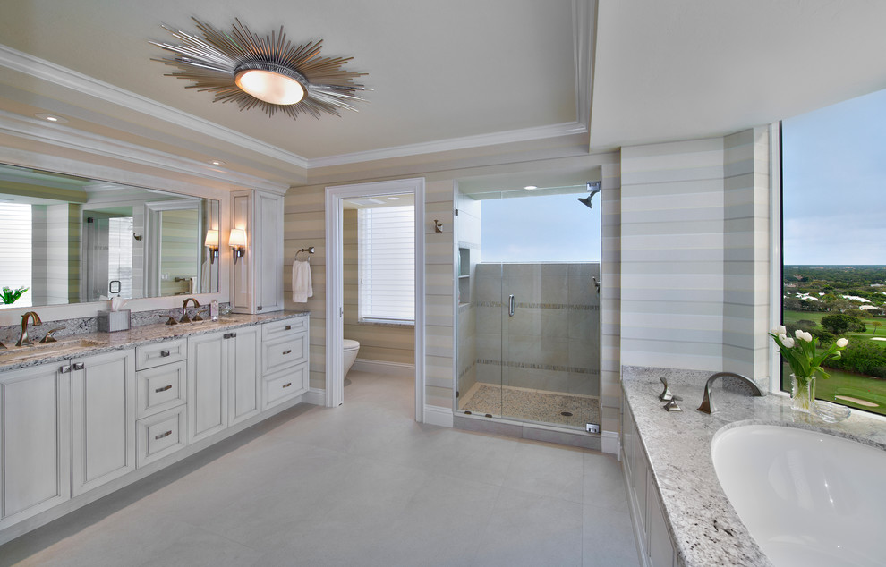 Large trendy master beige tile and porcelain tile alcove shower photo in Miami with an undermount sink, white cabinets, granite countertops, an undermount tub and raised-panel cabinets