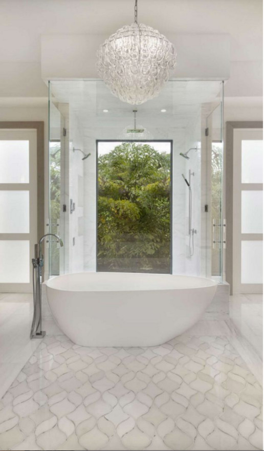 На фото: большая главная ванная комната в современном стиле с отдельно стоящей ванной, душем в нише, белыми стенами, мраморным полом и душем с распашными дверями с