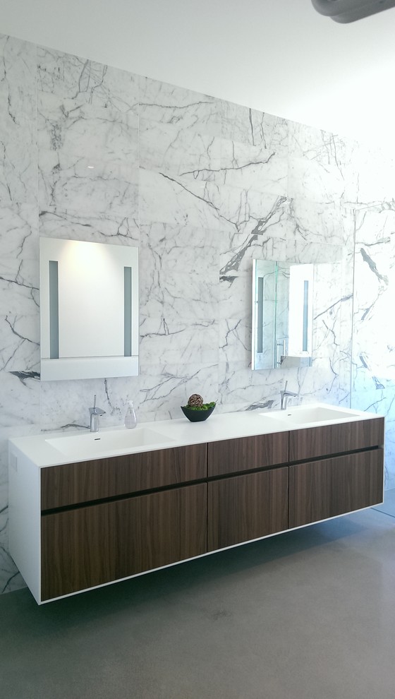 Modelo de cuarto de baño principal contemporáneo grande con armarios con paneles lisos, puertas de armario de madera en tonos medios, ducha esquinera, paredes blancas, suelo de cemento y lavabo integrado