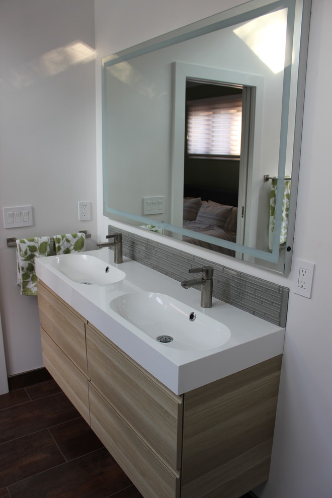 Photo of a contemporary ensuite bathroom in Cleveland with flat-panel cabinets, light wood cabinets, a freestanding bath, a corner shower, grey tiles, white walls, ceramic flooring, an integrated sink, marble worktops, brown floors and a hinged door.