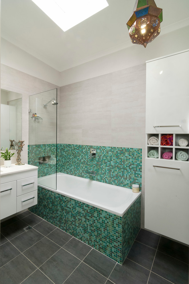 Idéer för ett mellanstort modernt badrum, med släta luckor, vita skåp, bänkskiva i kvarts, ett platsbyggt badkar, en dusch/badkar-kombination, grön kakel, mosaik och klinkergolv i keramik