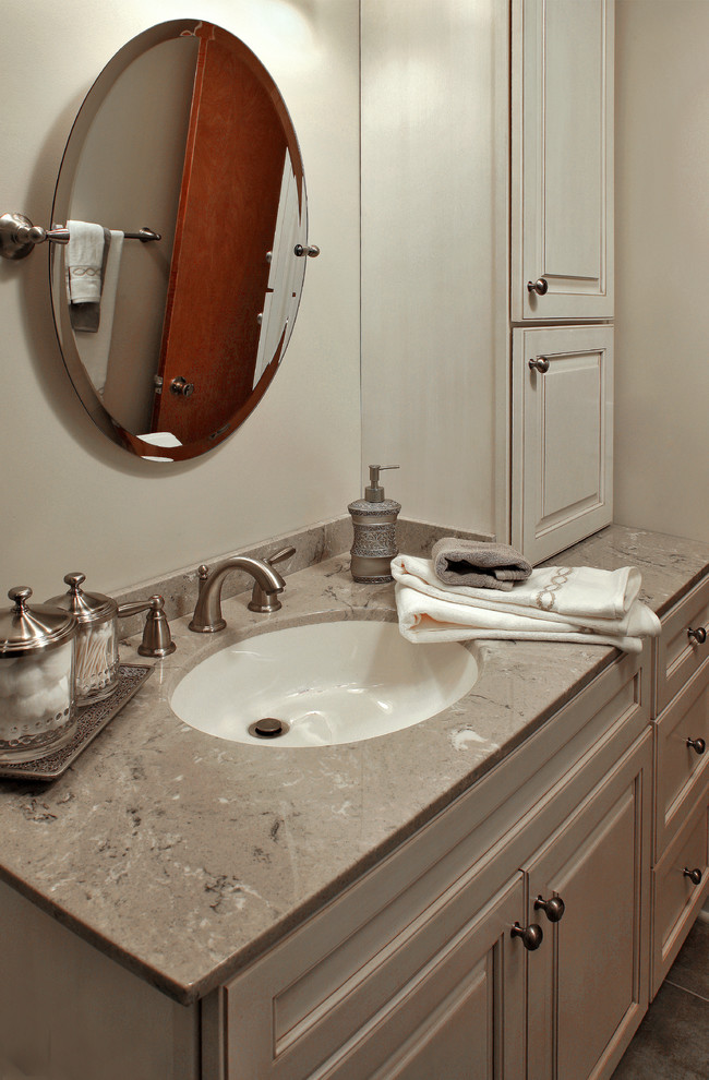Idéer för mellanstora vintage badrum med dusch, med luckor med upphöjd panel, vita skåp, en toalettstol med separat cisternkåpa, brun kakel, porslinskakel, beige väggar, en dusch i en alkov, klinkergolv i keramik, ett undermonterad handfat, bänkskiva i kalksten, brunt golv och dusch med skjutdörr